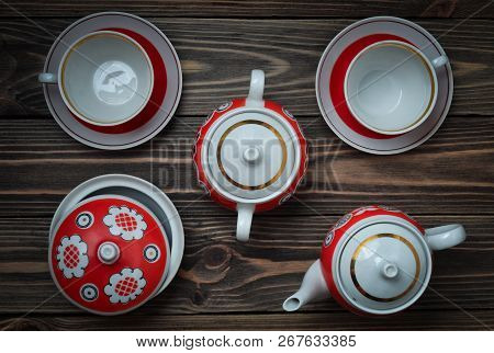 An Antique Set Of Ceramic Teapots, Cups, Saucers On A Wooden Table. Tea Ceremony. Top View.