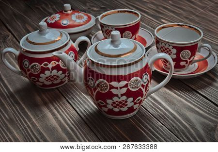 An Antique Set Of Ceramic Teapots, Cups, Saucers On A Wooden Table. Tea Ceremony.
