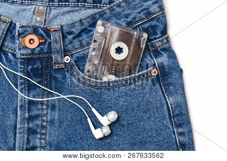 Audio Cassette In A Pocket Of Old-fashioned Blue Jeans And Headphones Isolated On A White Background