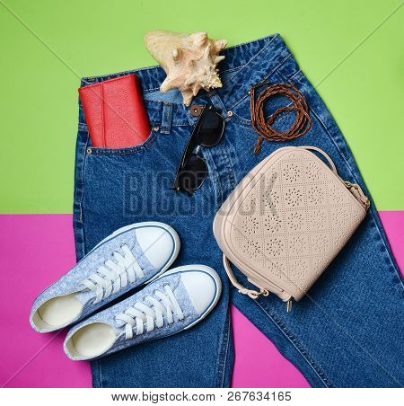 Women's Accessories Lie On Classic Jeans With An Overstated Waist. Sneakers, Purse, Bag, Belt On A P