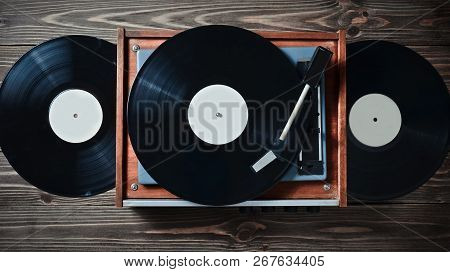 Vinyl Player With Plates On A Wooden Table. Entertainment 70S. Listen To Music. Top View.