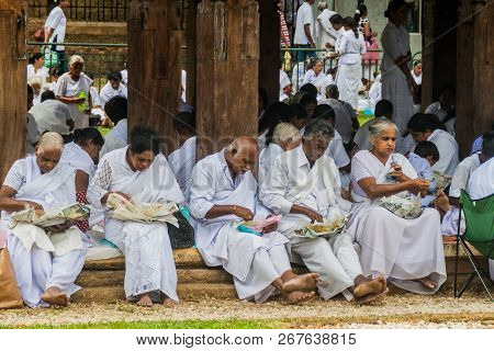 Kandy, Sri Lanka - July 19, 2016: White Clothed Buddhist Devotees Eat At The Grounds Of The Temple O