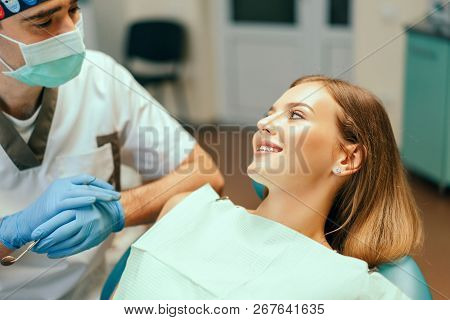 Dentist Examine Female Patient With Braces In Denal Office.