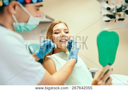 Dentist Showing Result Of Treatment For The Patient.