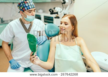 Dentist Showing Result Of Treatment For The Patient.