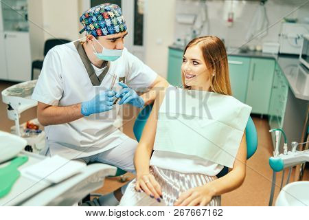 Dentist Examine Female Patient With Braces In Denal Office.
