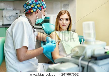 Dentist Examine Female Patient With Braces In Denal Office.