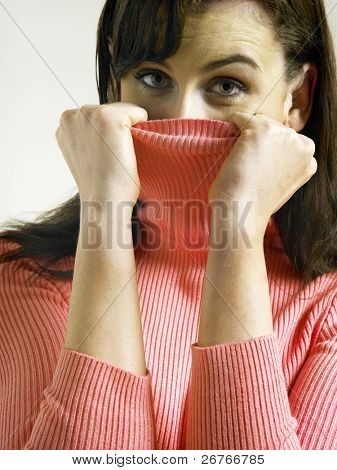 女性のタートルネック、カメラ目線で顔を覆う