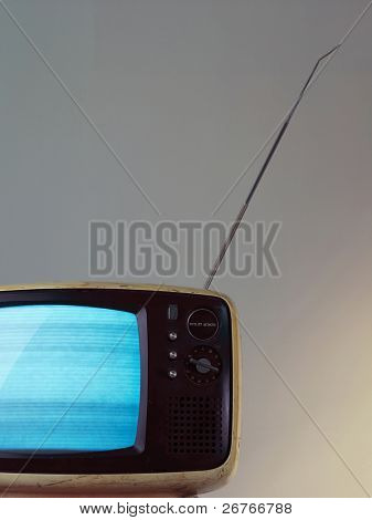 Old televison isolated on greyish background.