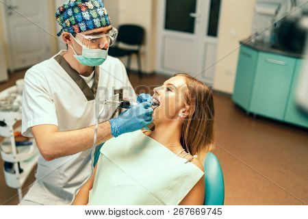 Dentist Examine Female Patient With Braces In Denal Office.