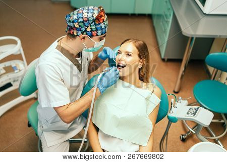 Dentist Examine Female Patient With Braces In Denal Office.