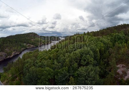 Typical Swedish nature and houses on the shore of the fjord. View from the high bridge over the fjord. The border of Norway and Sweden.June 18,2018.Near the town Selater,Sweden