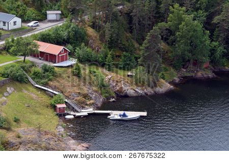 Typical Swedish nature and houses on the shore of the fjord. View from the high bridge over the fjord. The border of Norway and Sweden.June 18,2018.Near the town Selater,Sweden