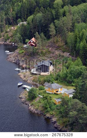 Typical Norwegian nature and houses on the shore of the fjord. View from the high bridge over the fjord. The border of Norway and Sweden.June 18,2018.Near the town Selater,Sweden