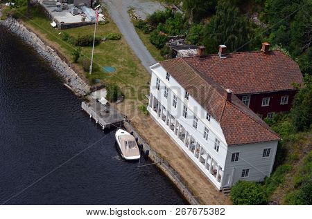 Typical Norwegian nature and houses on the shore of the fjord. View from the high bridge over the fjord. The border of Norway and Sweden.June 18,2018.Near the town Selater,Sweden
