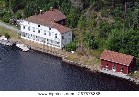 Typical Norwegian nature and houses on the shore of the fjord. View from the high bridge over the fjord. The border of Norway and Sweden.June 18,2018.Near the town Selater,Sweden