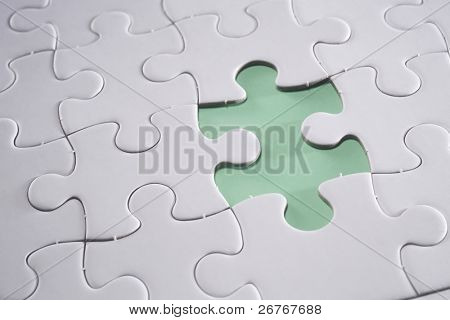 Jigsaw puzzle with missing piece isolated on green background.