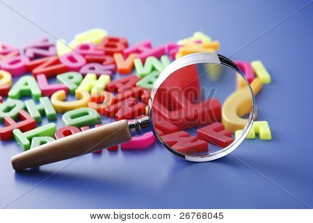 Lente magnifing il mucchio di lettere.