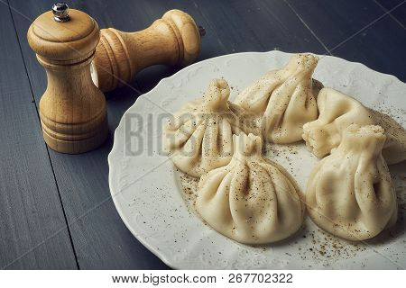 Traditional Chinese Or Asian Food, Steamed Dumpling Served On White Plate With Salt And Pepper