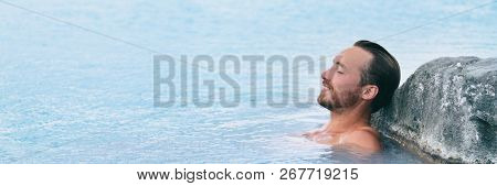 Wellness Spa man relaxing in hot springs outdoor at luxury resort spa retreat. Handsome young male model with eyes closed resting in natural water pool on travel vacation holiday. banner background.