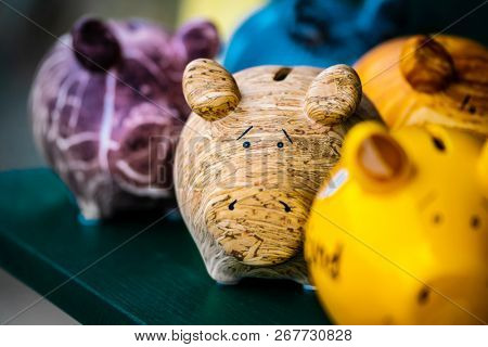 Colorful ceramic pig shape copycats on the wooden shelf