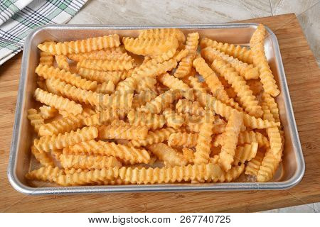 A Baking Pan With Hot Crinkle Cut French Fries Fresh  Out Of The Oven