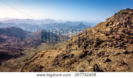 Scenic overlook of Al Hajar mountains in the emirate of Fujairah, UAE and a village in a valley