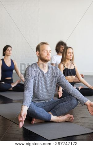 Group Of Young Sporty People In Lotus Pose