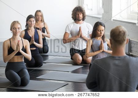 Group Of Sporty People In Vajrasana Exercise
