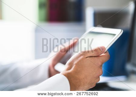 Doctor And Medical Professional Using Tablet At Work In Health Care. Physician Using Digital Electro
