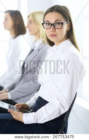Attractive Business Woman Working With A Tablet Pc Against The Background Of Colleagues. Lawyer Or S
