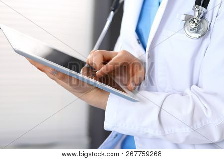 Woman Doctor Using White Tablet Computer While Working In Hospital, Close-up