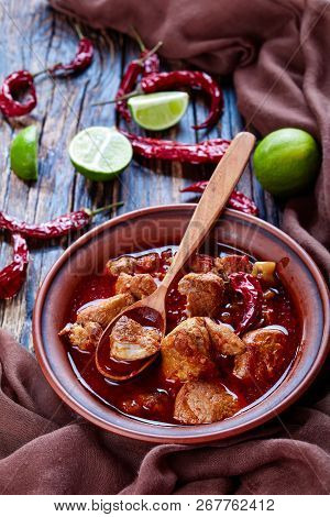 Carne Adobada Or Hearty Red Chile And Pork Stew In A Clay Bowl With Spoon On An Old Wooden Table Wit