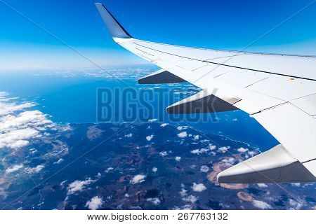 Wing Of Airplane Above Island With Blue Sky