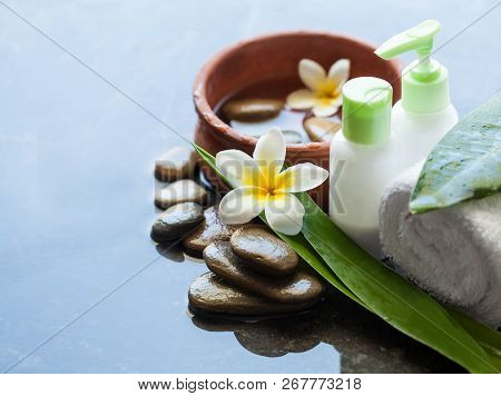 Many Stones With White Flowers And Oil Bottels