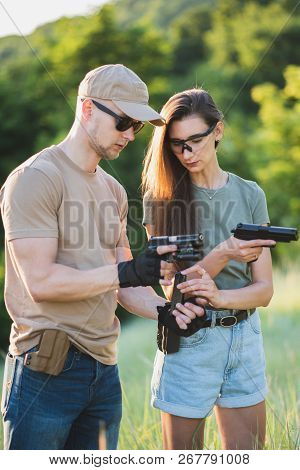 The Instructor Teaches The Girl To Shoot A Pistol At The Range