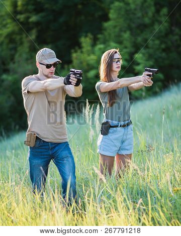 The Instructor Teaches The Girl To Shoot A Pistol At The Range