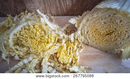 Sliced Chinese Cabbage And A Half Head On The Kitchen Board.