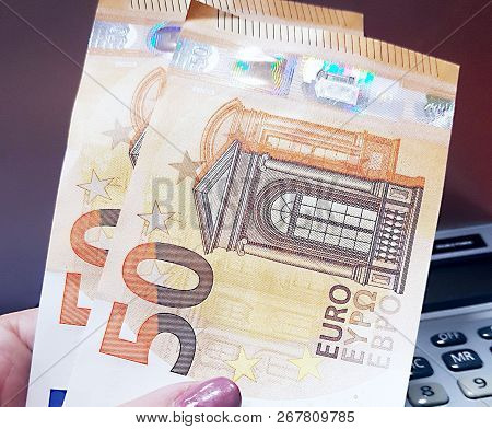 Currency Fifty Euros In Female Hands. Calculator In The Background
