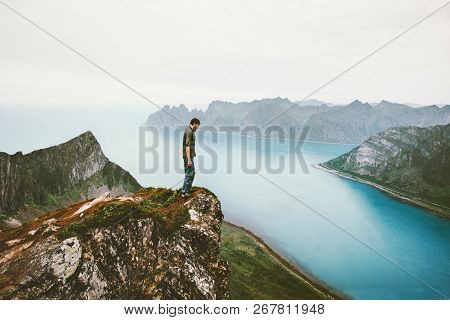 Man Traveler Standing Alone On Cliff Mountain Edge Above Fjord Sea Adventure Lifestyle Vacations Out