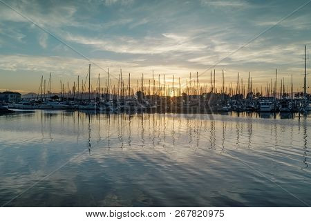 Sun Setting On Emeryville Marina. Sailboats Moored In San Francisco Bay With Sunset Skies And Water 