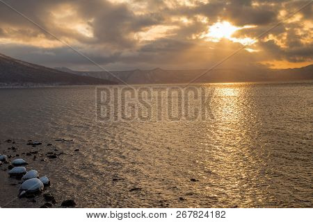 Sunset Light At Lake Shikotsu Near Yamasentetsu Bridge With Snow Ground And Water In Winter Season.