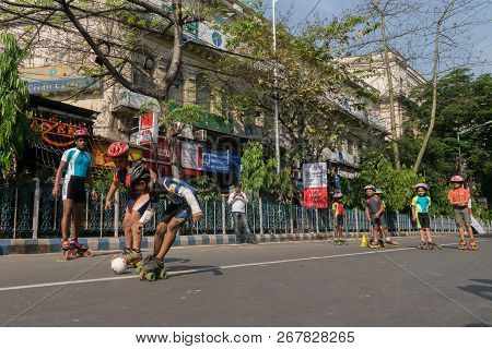 Kolkata, West Bengal, India - March 15th 2015 : Children Rollerskating With White Ball On Park Stree