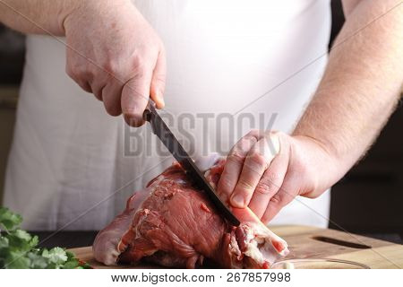 Chef Butcher Cutting Lamb Meat With Knife On Kitchen, Cooking Proteine Food