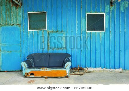 alten verlassenen Haus Front mit blauen sofa