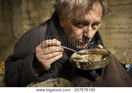Ugly Pauper Man Living Outdoor Eating Lentil Soup On Street