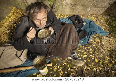 Ugly Pauper Man Living Outdoor Eating Lentil Soup On Street