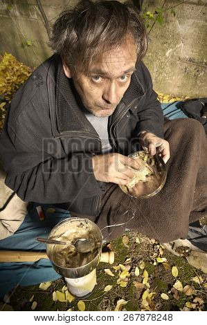 Ugly Pauper Man Living Outdoor Eating Lentil Soup On Street