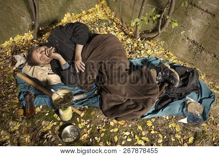 Ugly Pauper Man Living Outdoor Sleeping, Relaxing And Laying Alone On Hidden Urban Place
