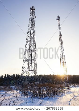 Telecommunication Towers At Sunset. Ladders, Support Towers And Metal Structures Cell Towers. Vertic